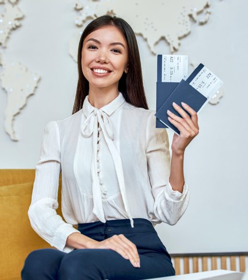 young-woman-travel-agent-with-flight-tickets-in-hands.jpg